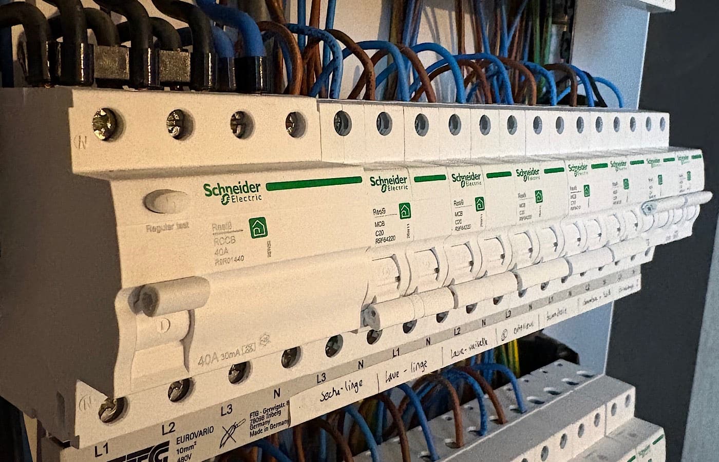 Différentiel 40 A 30 mA et disjoncteurs Schneider, chaque circuit repéré à la main : lave-linge, sèche-linge, lave-vaisselle